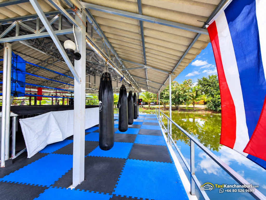 Covered Muay Thai training area with punching bags overlooking a pond at White Wolf Muay Thai Academy