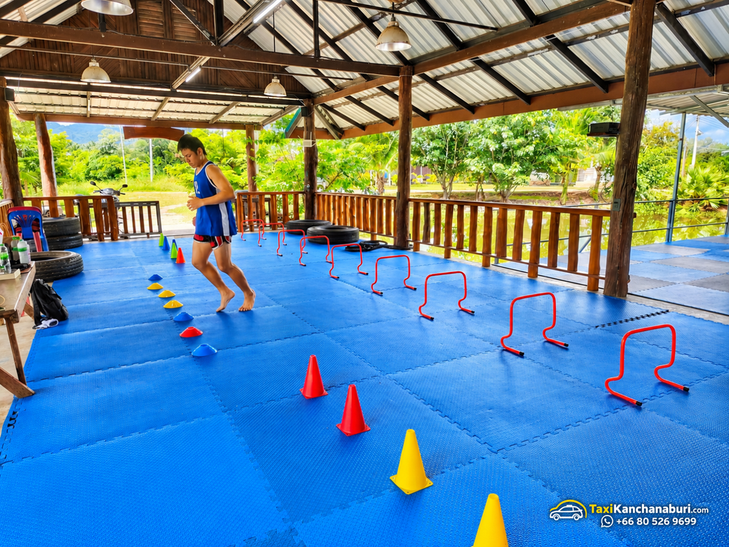 Muay Thai athlete practicing agility drills on blue training mats at White Wolf Muay Thai Academy in Kanchanaburi